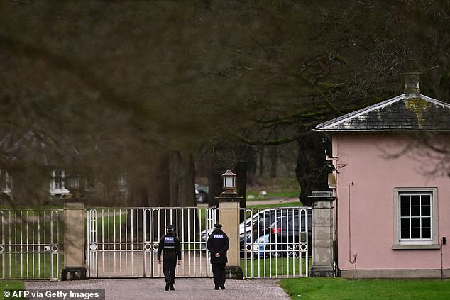 Police officers walk through the Bishops Gate entrance leading to Royal Lodge, a 30-room property and former residence to Andrew Mountbatten-Windsor