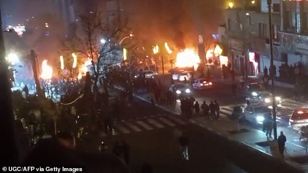 This video grab taken on January 14, 2026 from UGC images posted on social media on January 9, 2026 shows cars set on fire during a protest on Saadat Abad Square in Tehran