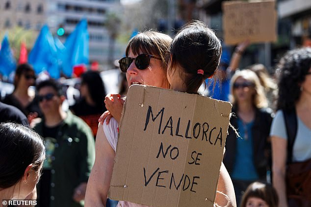 'Mallorca is not for sale' reads a protest banner held by a girl in a march against housing prices and the impact of tourism on the residents of the Balearic Islands, in Palma, Mallorca, Spain, April 5, 2025