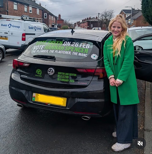 Ms Spencer poses beside what appears to be a petrol-powered car with campaign slogans