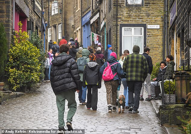 But not everyone seems happy. There are mutterings of 'overtourism' while the village's steep and narrow streets have long been plagued with parking chaos and traffic gridlock. Pictured: Visitors on Haworth's Main Street