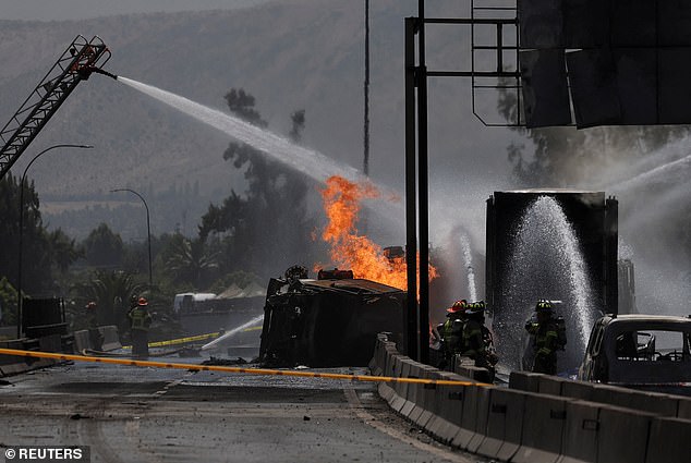 Firefighters and first responders work at the site of the deadly explosion, spraying water in an attempt to extinguish the flames