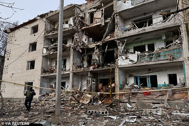 A rescuer walks in front of an apartment building hit by a Russian air strike in the town of Komyshuvakha, amid Russia's attack on Ukraine, in Zaporizhzhia region, Ukraine February 20, 2026