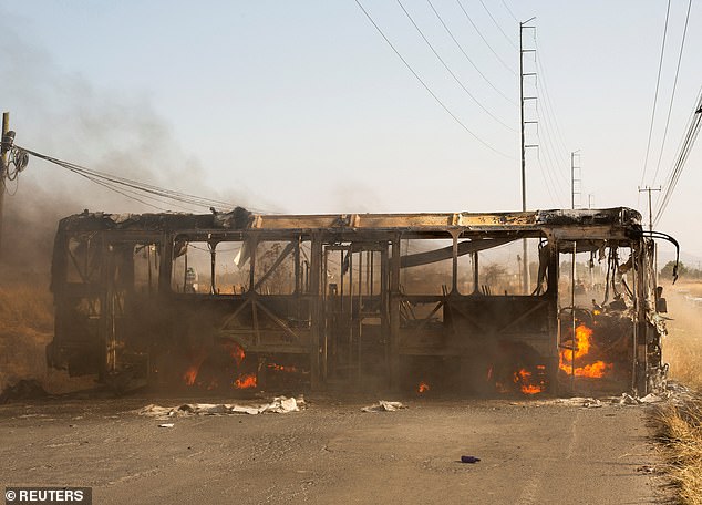 A bus used as a roadblock by organized crime burns following a federal operation in which a government source said Mexican drug lord Nemesio Oseguera, commonly known as 'El Mencho,' was killed