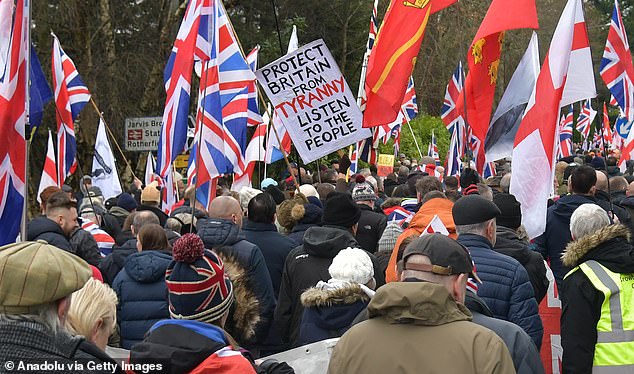 Pictured: Protestors wave flags and banners outside the Crowborough Training Camp on January 25