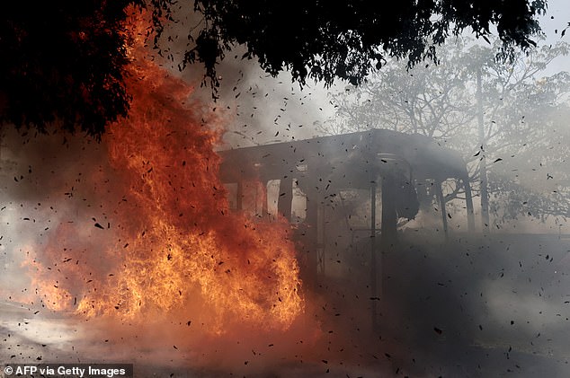 A bus set on fire by organised crime groups in response to an operation in Jalisco to arrest a high-priority security target, burns at one of the main avenues in Zapopan, state of Jalisco, Mexico, on February 22, 2026. Armed civilians blocked several roads in the state of Jalisco, in western Mexico, following an operation by federal forces in the town of Tapalpa, local authorities reported. Jalisco, which will host four matches of the upcoming 2026 World Cup, is home to the powerful Jalisco New Generation Cartel (CJNG), and has been rocked by several episodes of violence in recent years. (Photo by Ulises RUIZ / AFP via Getty Images)