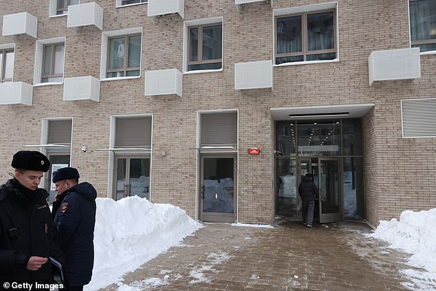 Russian Police officers walk next to the entrance of a residential building on Volokolamsk Highway, where an assassination attempt on Lt. Gen. Alexeyev was made on February 6