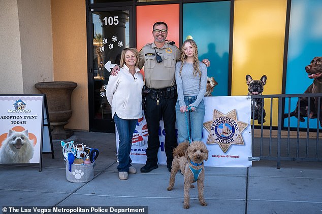 Officer Black and his family posing outside the rescue agency, after the adoption of Jet Blue was finalized