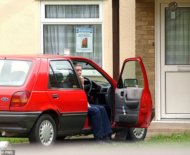 Huntley pictured outside his house No.5 College Close which had a poster for the missing girls displayed prominently in the front room window