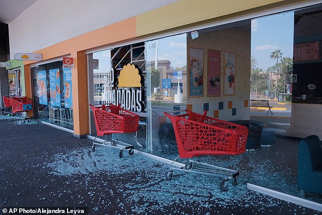 Tourists trapped in resorts have revealed that food and water supplies are running low after panic buying at local shops. Pictured are carts outside of a vandalized supermarket in Guadalajara, Jalisco on Sunday