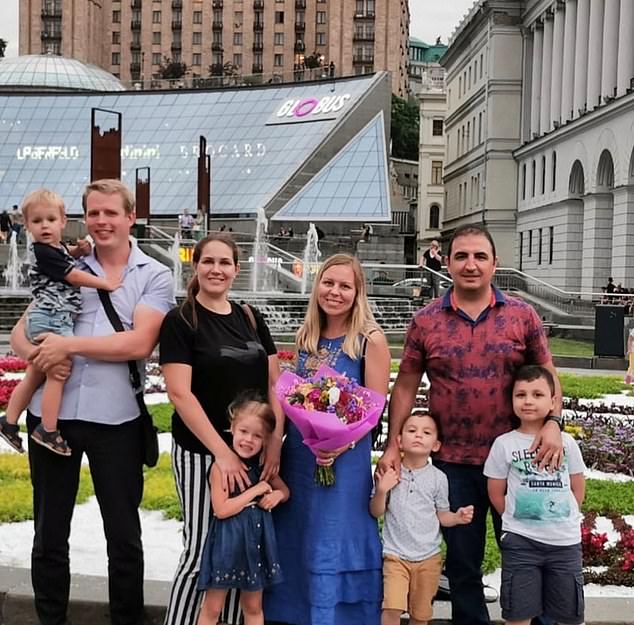 Mrs Rizak and her two children with family friends in Kyiv before the war. Mrs Rizak is eager to eventually return to her homeland