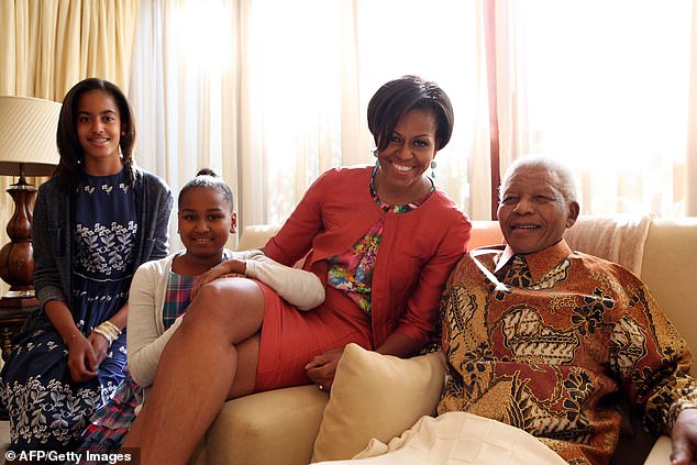 Nelson Mandela (R) posing with former US First Lady Michelle Obama (2ndR) and her daughters Malia (L) and Sasha at his home in Johannesburg in 2011