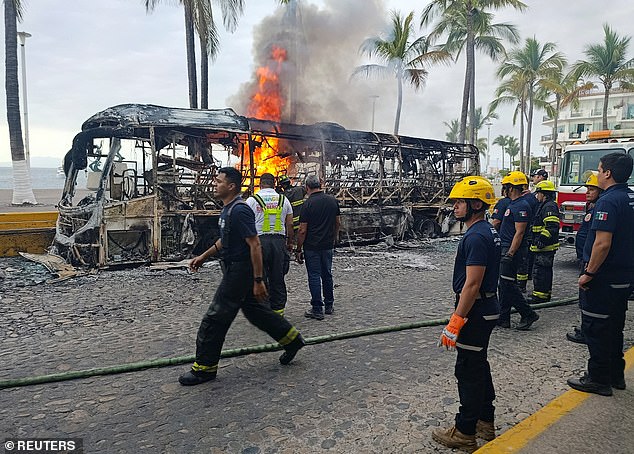 Firefighters work to extinguish flames from buses set on fire by in Puerto Vallarta, Jalisco