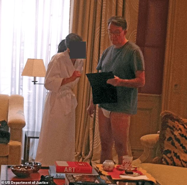 In this photo, Lord Mandelson stands in white underwear talking to a woman in a bathing robe