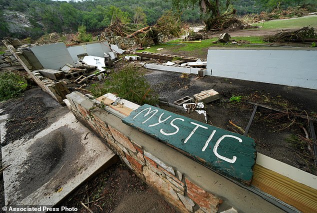 A Camp Mystic sign is seen near the entrance to the establishment along the banks of the river