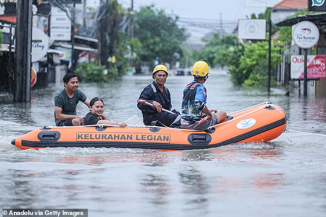 Frightening moment massive snake swims through Bali street as tourist island floods