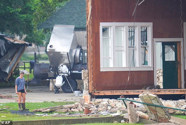 A person looks at damage to the main building at Camp Mystic along the banks of the Guadalupe River after a flash flood swept through the area, last July in Hunt, Texas