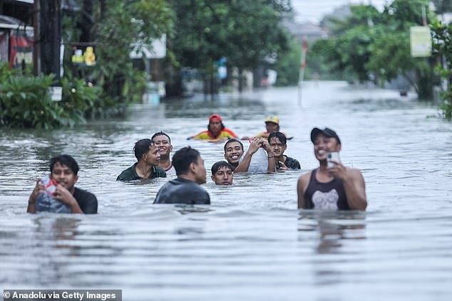 Locals make their way through the floodwaters