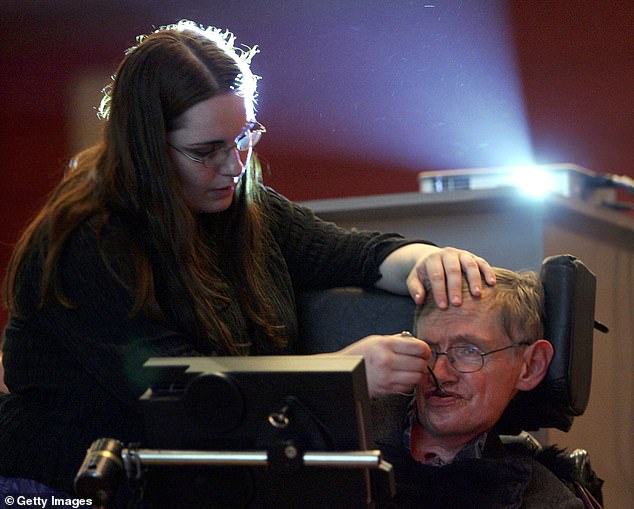 One of Hawking's assistants feeds him water as he listens to the lecture of Prominent Chinese mathematician Shing-Tung Yau, a professor at Harvard University during the 2006 International Conference on String Theory on June 20, 2006 in Beijing, China