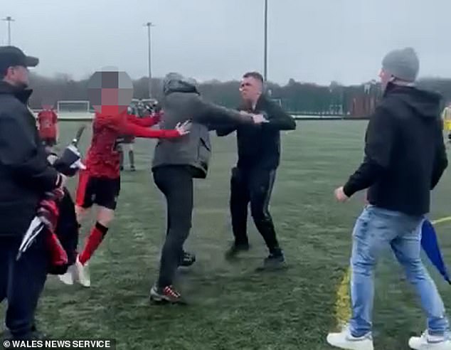 Children still in their kit tugged at the fighting adults to break up the fight