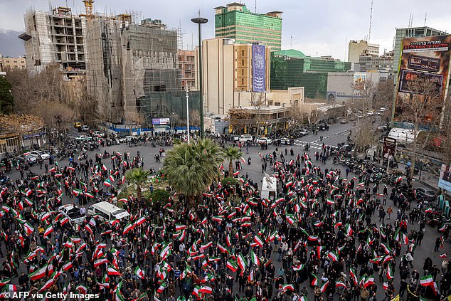 Protesters gather with Iranian national flags during a demonstration in support of the government outside a mosque in Tehran