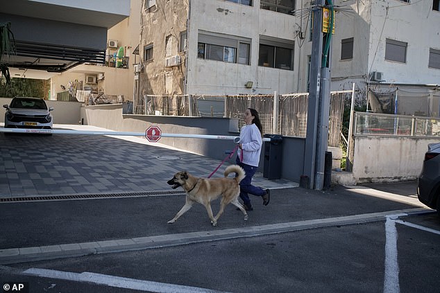 A woman runs with her dog for shelter in Haifa, northern Israel after the US and Israel launch strikes on Iran