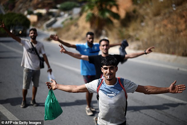 Migrants pose for a picture while being escorted to the Ceuta-Morocco border in the Spanish North African enclave of Ceuta