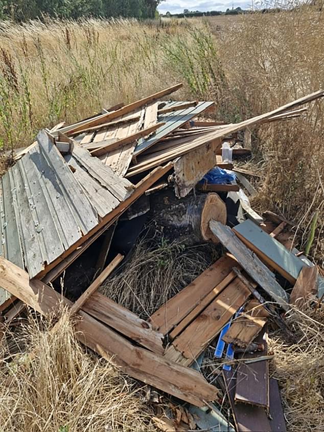 Wooden panels, which appear to have been part of fencing or a garden shed, are left in the middle of a field on the estate