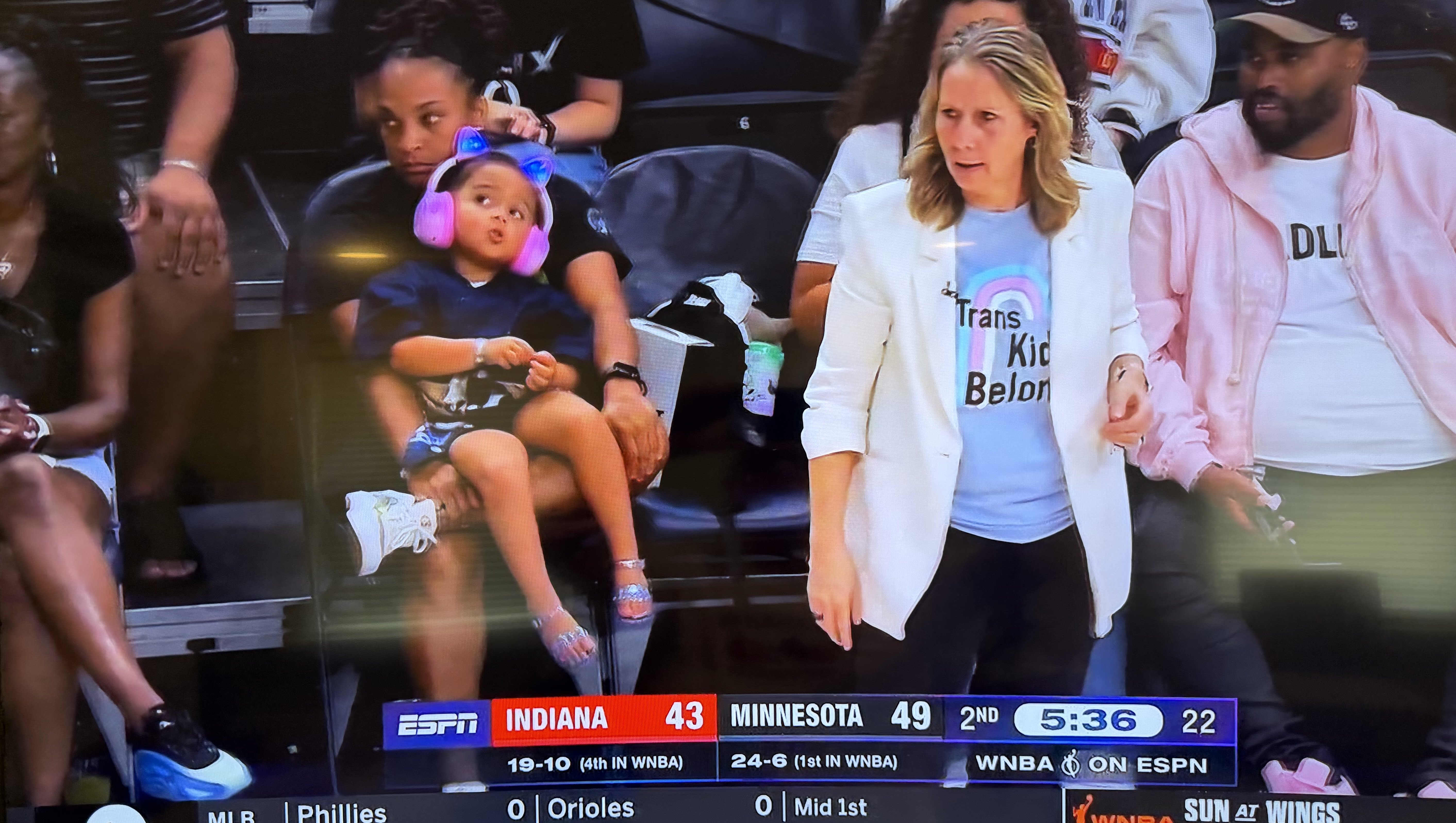 SICK: Crazy Minnesota Lynx Coach Wears “Trans Kids Belong” T-Shirt to Fever Game with Sophie Cunningham
