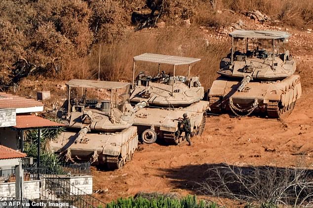 Israeli battle tanks deploy in the village of Zawtar al-Sharqiyah (Eastern Zawtar) in southern Lebanon as pictured from the nearby village of Zawtar al-Gharbiyah