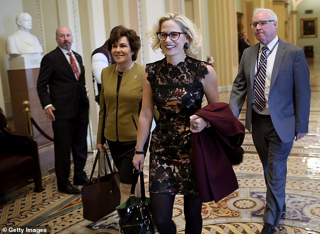 Sinema walks to meet Senator Chuck Schumer in the US Senate