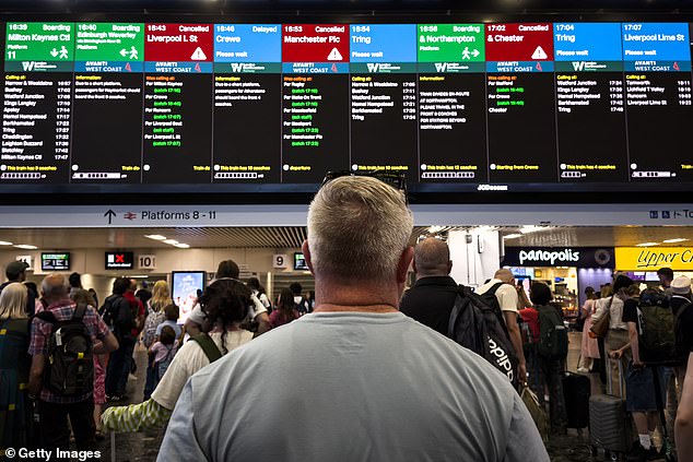 Commuters wait inside Euston stations. The cause of the power outage is an 'external power supply failure' in the Ardwick area of Manchester, according to Network Rail