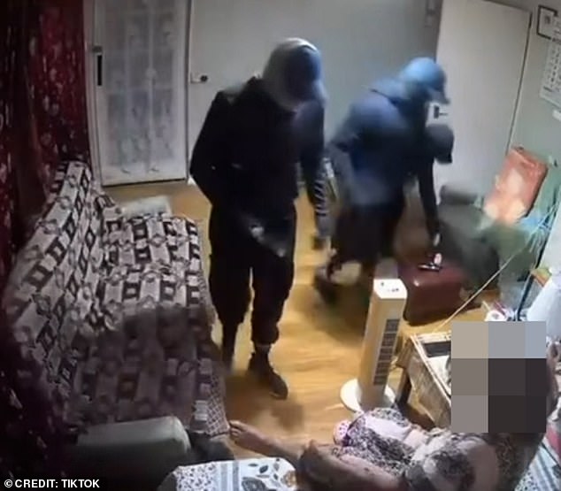 The startled pensioner then gets out of bed as one of the men, carrying what appears to be a weapon, approaches the woman ordering her to be quiet