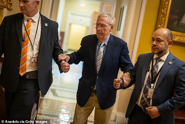 McConnell, who had polio as a child, is supported by staffers inside the US Capitol in early June
