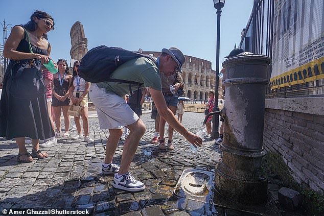 Tourists wait to fill up their water bottles at a drinking fountain in Rome in the scorching heat on August 6, 2026