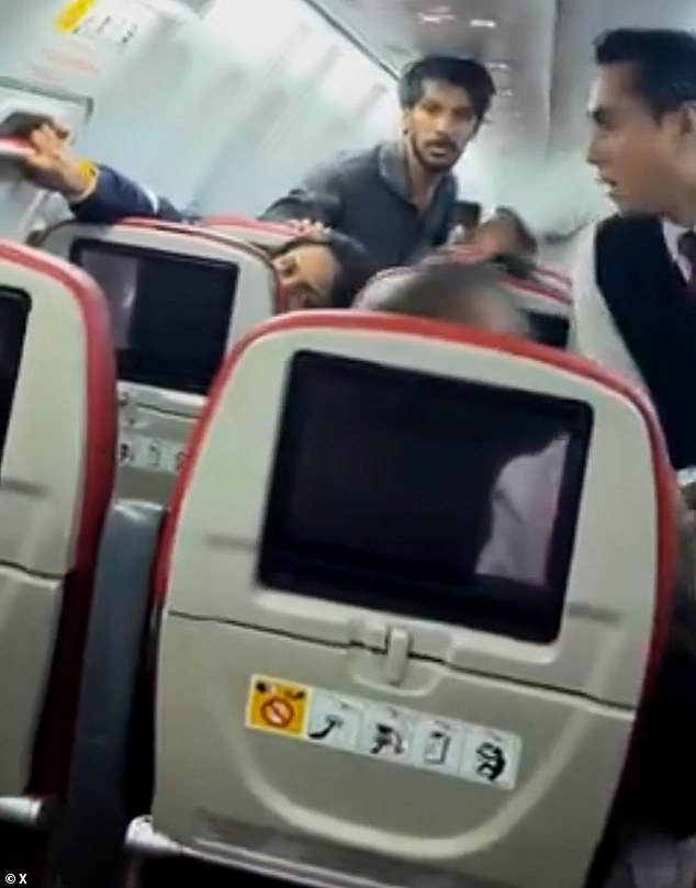 Terrifying moment plane passenger tried to open emergency exit at 30,000 feet 'because he felt like it' as he is arrested for attempted murder of his fellow flyers