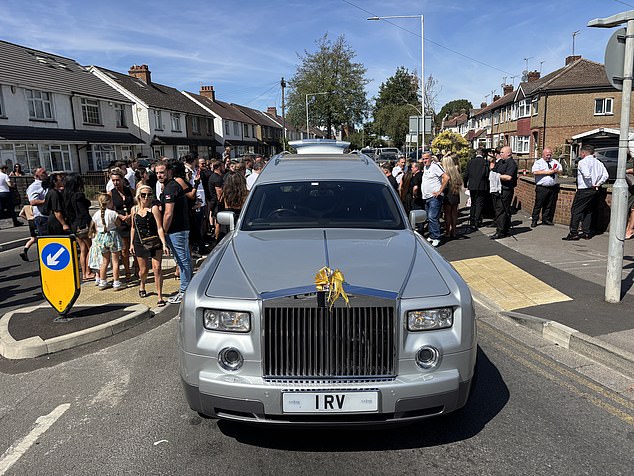 A large silver Rolls-Royce hearse was also pictured making its way down a street while friends and family watched on