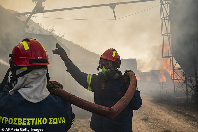 Firefighters work to extinguish a fire that broke out at a livestock facility near Kouvaras, south of Athens, on August 10, 2026