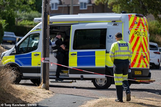 Officers stand next to a police cordon at the scene of the explosion