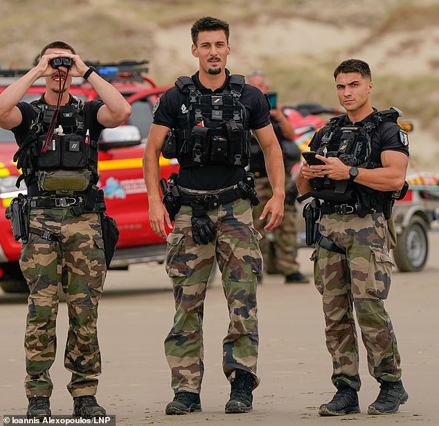 French police watched on from the beach as migrants crowded onto a mega-dinghy bound for the UK