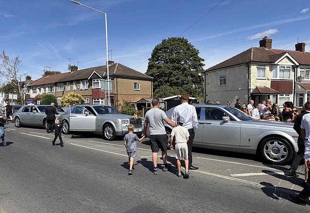 Funeralgoers gather outside the hearse as Mr Hanrahan's body is taken through the streets of west London