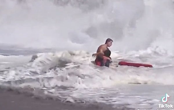 A 16-year-old lifeguard rescues a young boy from monster waves in Santa Cruz, California, on Saturday, July 25, 2026 (Video screenshot)