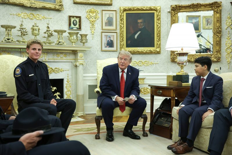 WASHINGTON, DC - AUGUST 17: U.S. President Donald Trump meets with 16-year-old California State Parks lifeguard Ryder Williams (L) in the Oval Office at the White House on August 17, 2026 in Washington, DC. Williams rescued 10-year-old Nathaniel Rai (R) in rough surf at Seabright Beach in Santa Cruz, California in July. (Photo by Alex Wong/Getty Images)