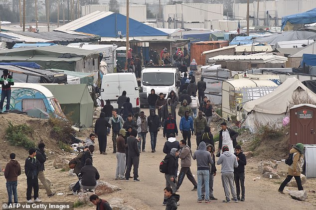 Migrants gather together inside the camp during the full evacuation of the Calais 'The Jungle' camp in 2016