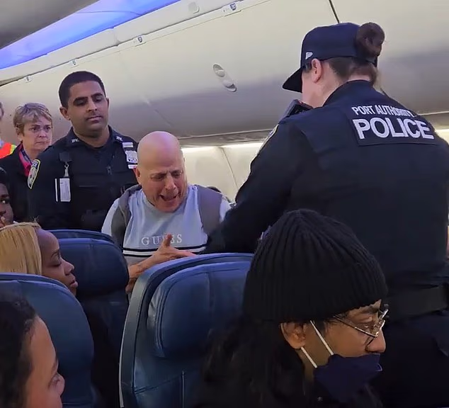 Man filmed hurling foul-mouthed racist abuse while being escorted off packed Delta plane in New York