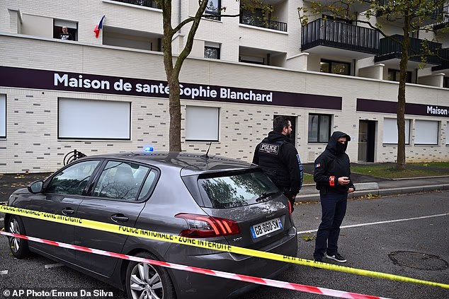 Policemen stand guard in front of a health center after a shooting left one person dead and four others wounded in Trappes, outside Paris, Friday, October 23, 2026