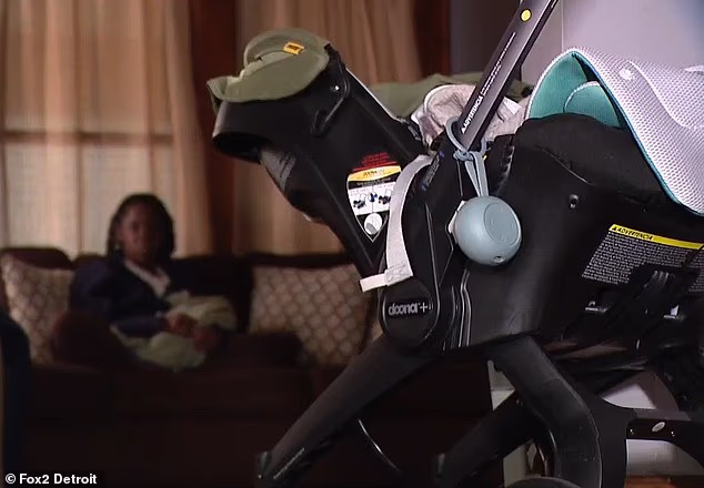 The baby's stroller and car seat are pictured inside the home as his injured mother sits in the background. She claims she endured a ten-minute beating weeks after having a C-section