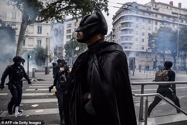 A protester wearing a Batman costume looks on during a demonstration in Lyon