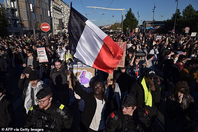 A protester holds a French flag during nationwide demonstrations over the rising cost of living and inequality