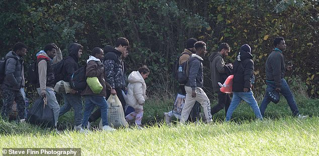 A group of migrants, including children are seen heading towards a beach in northern France